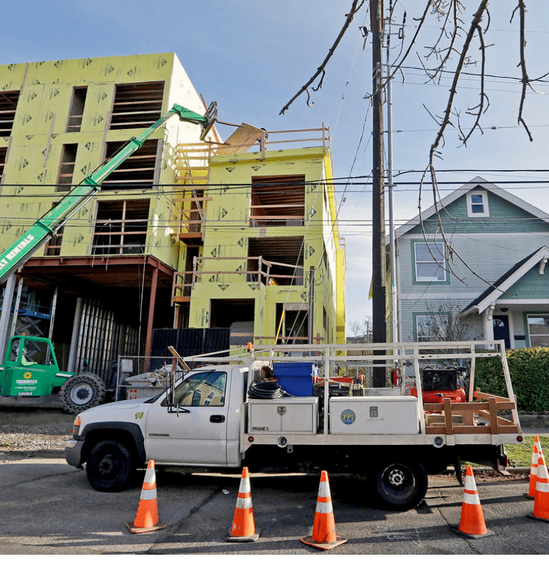 FILE - In this Dec  13, 2017 file photo, a four-story mixed-use building is under construction adjacent to an older, single-family home in Seattle  A massive influx of new residents and an ensuing housing crunch has led to skyrocketing rents  On Monday, Feb  10, 2020, the Seattle City Council unanimously approved a ban on evictions during December, January and February  (AP Photo Elaine Thompson, File)