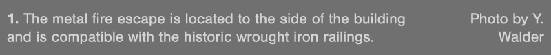 1  The metal fire escape is located to the side of the building  Photo by Y  and is compatible with the historic wrou   